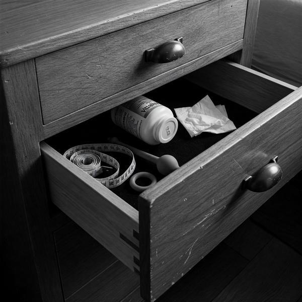 The Drawer – Male Intimacy and Ritual Preparation Open drawer containing measuring tape, supplements, and intimate tools used for male body ritual and clinical exposure.